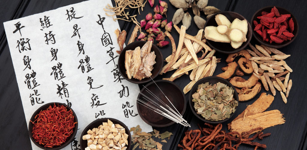An array of Chinese herbs, acupuncture needles, and a list written in Mandarin or Cantonese